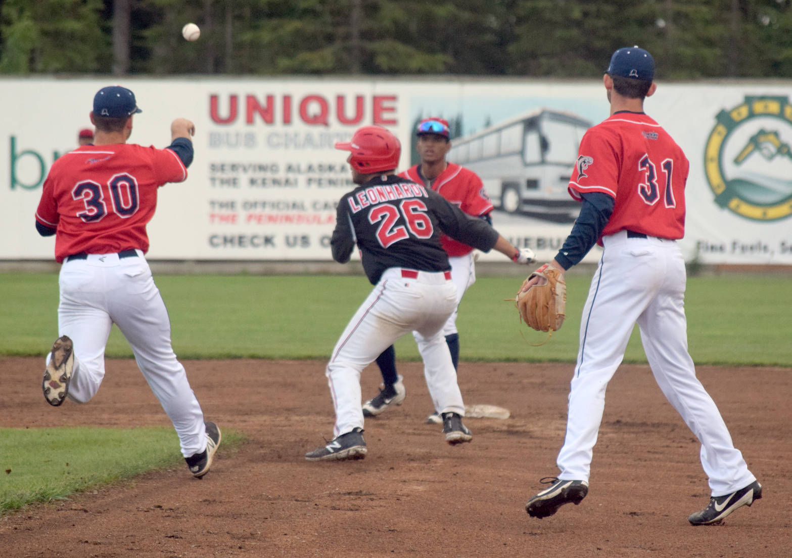 Danny Dopp of the Chugiak-Eagle River Chinooks tosses to Gregory Ozuna to retirie Oilers’ Brian Leonhardt in a rundown Thursday, June 21, 2018, at Coral Seymour Memorial Park in Kenai. (Photo by Jeff Helminiak/Peninsula Clarion)