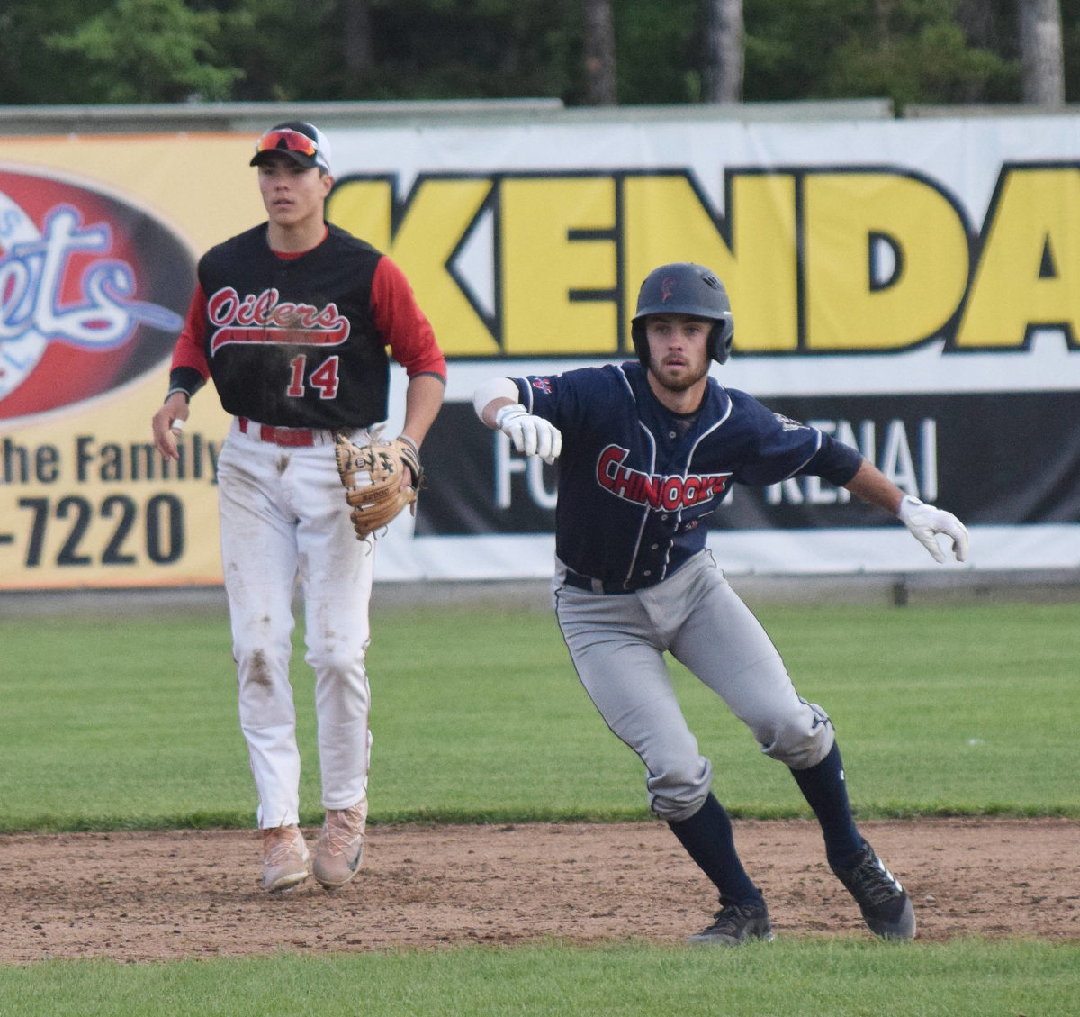 Chugiak/Eagle River Chinooks baserunner Luke VanDover tries to time a move with Peninsula Oilers shortstop Bryan Woo watching closely Friday night at Coral Seymour Memorial Park in Kenai. (Photo by Joey Klecka/Peninsula Clarion)