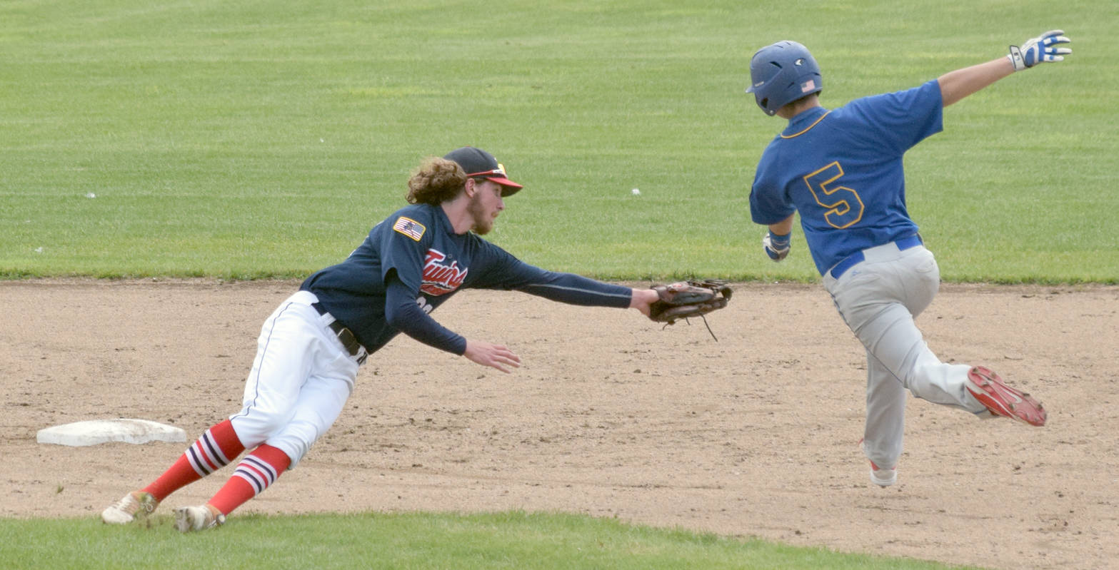 Kodiak’s Jace Crall eludes the tag of Twins second baseman David Michael in the fourth inning Monday, June 25, 2018, at Coral Seymour Memorial Park in Kenai. (Photo by Jeff Helminiak/Peninsula Clarion)