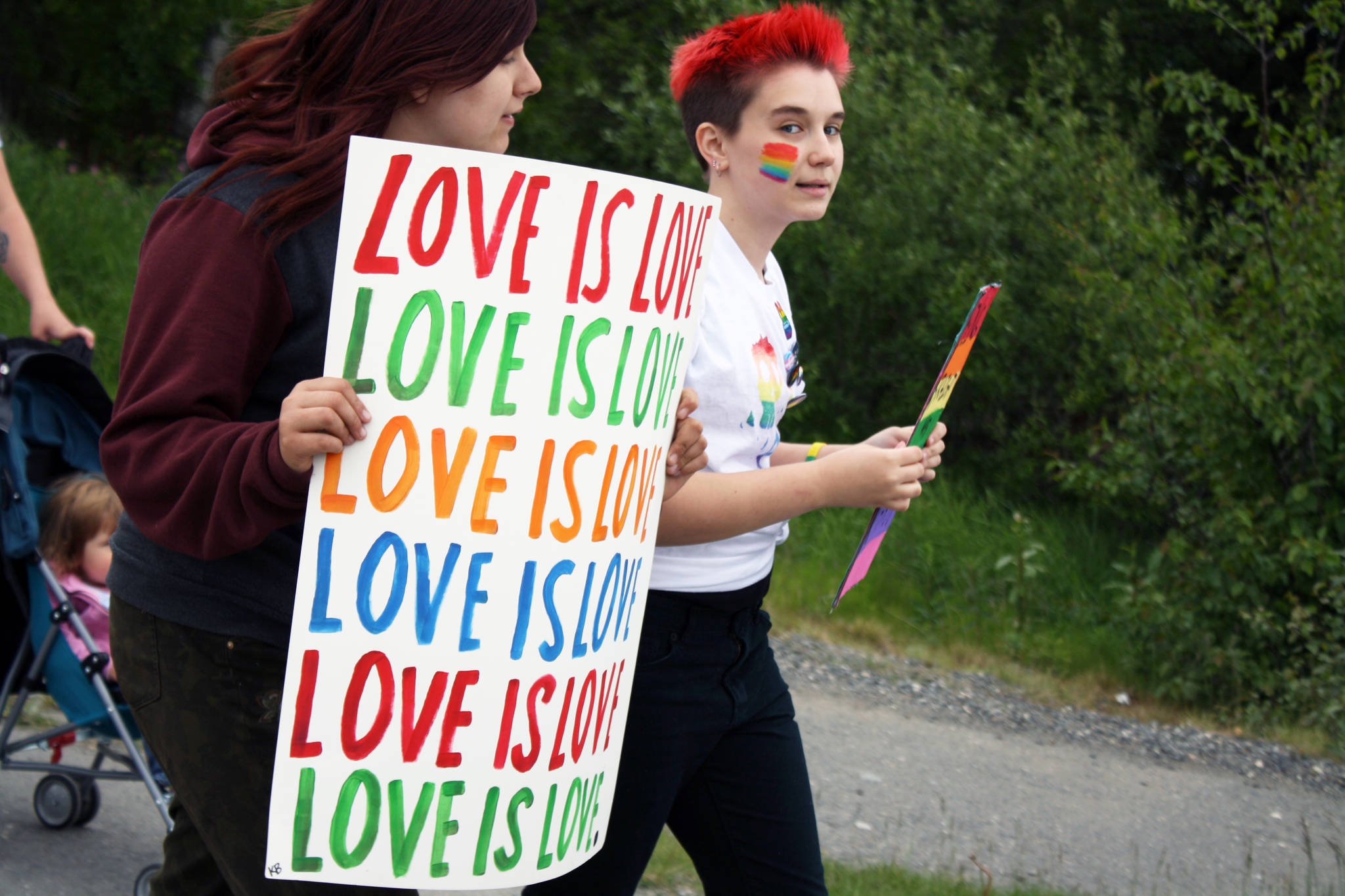 Two marchers celebrate LGBTQ Pride during the Two Spirit march from the Soldotna Sports Complex to Soldotna Creek Park. About 60 people turned out to take part in the march, which was part of wordwide celebrations commemorating the beginning of the LGBTQ civil rights movement. (Photo by Erin Thompson/Peninsula Clarion)
