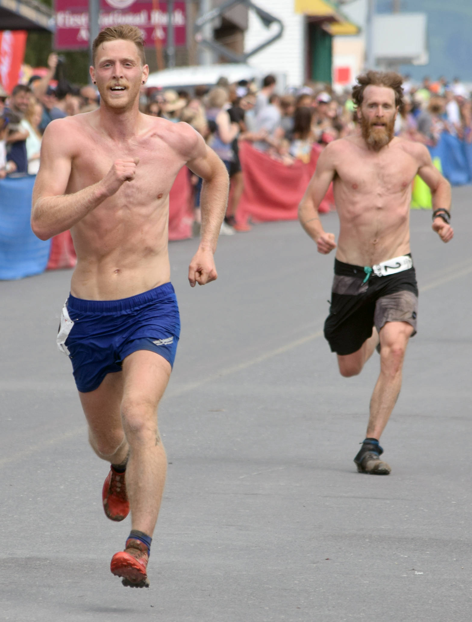 Anchorage’s Lars Arneson, a 2009 graduate of Cook Inlet Academy, passes Seward’s Erik Johnson to take seventh place at the Mount Marathon Race on July 4, 2018, in Seward. Johnson finished eighth.(Photo by Jeff Helminiak/Peninsula Clarion)