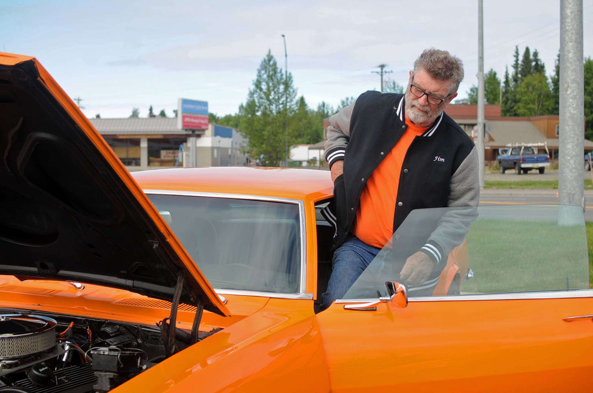 Jim McEwen steps into the classic car he restored at Autozone on Saturday, June 30, 2018 in Soldotna, Alaska. McEwen is a member of the Kaknu Kruzers, a local club composed of members who restore classic cars. The club has a number of events and rives throughou the summe, including the upoming car show at the Soldotna Progress Days parade on July 28. (Photo by Elizabeth Earl/Peninsula Clarion)