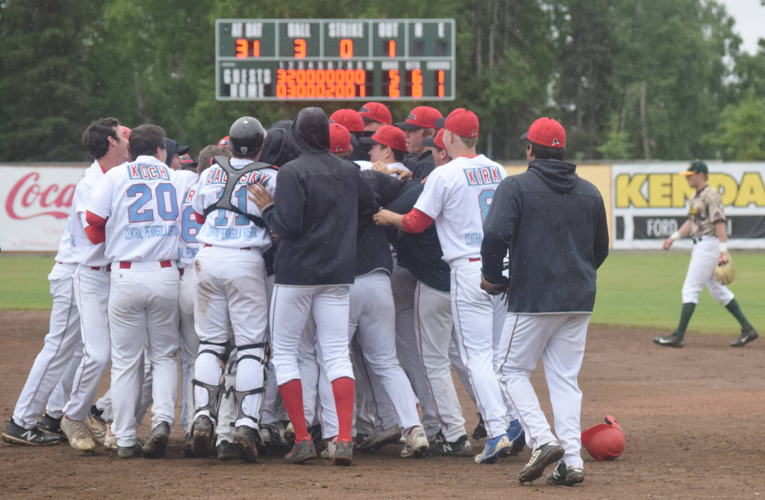 The Peninsula Oilers mob Chad Bible after his single in the ninth inning delivered a 6-5 victory over the Mat-Su Miners on Sunday, July 8, 2018, at Coral Seymour Memorial Park in Kenai. (Photo by Jeff Helminiak/Peninsula Clarion)