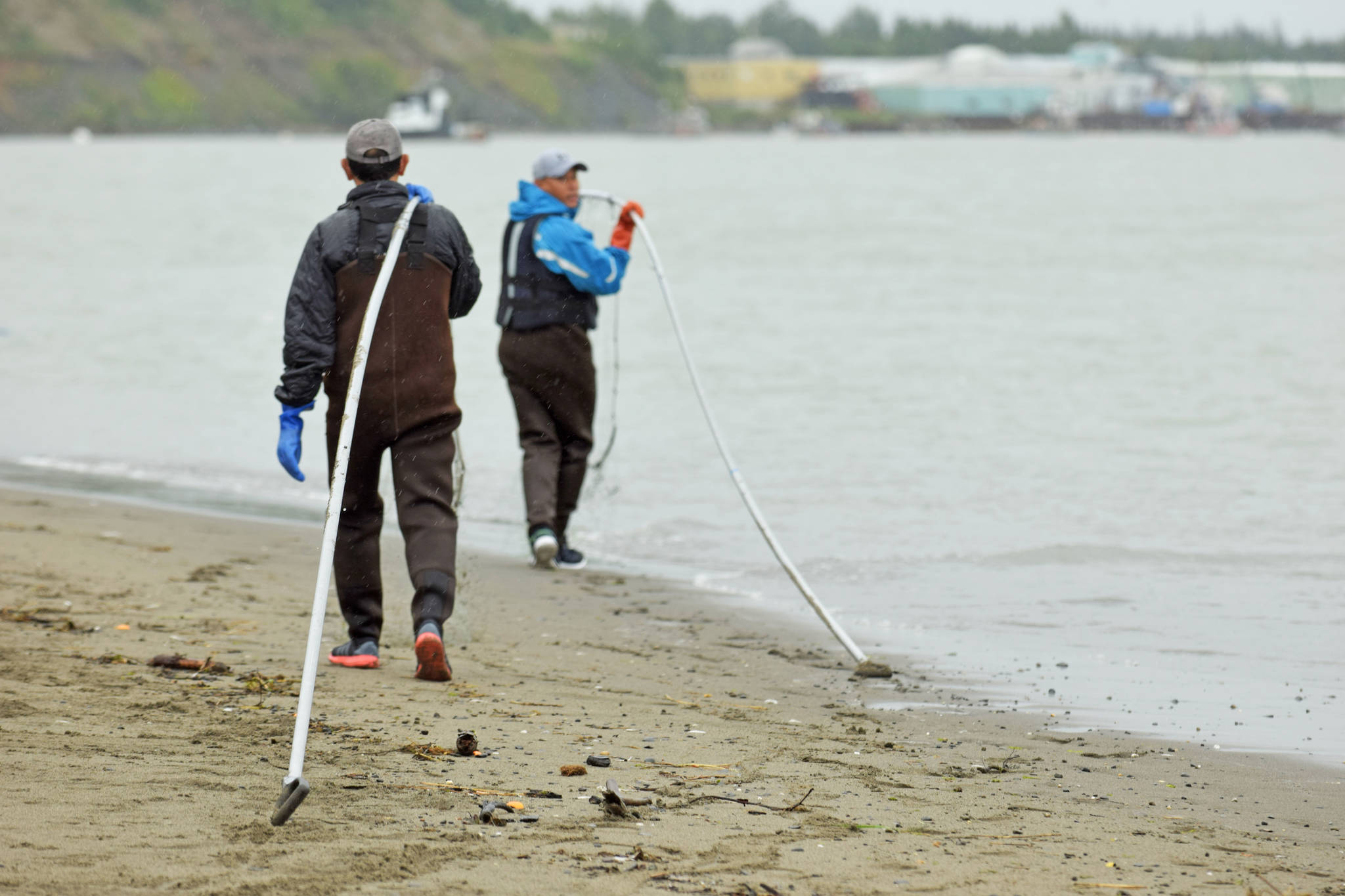 Dipnetters carry their dipnets to the water at Kenai Beach on Tuesday, July 10, 2018 in Kenai, Alaska. Tuesday marked the opening of the three-week dipnetting season, during which Alaska residents can harvest salmon and flounder for personal use. (Photo by Erin Thompson/Peninsula Clarion)