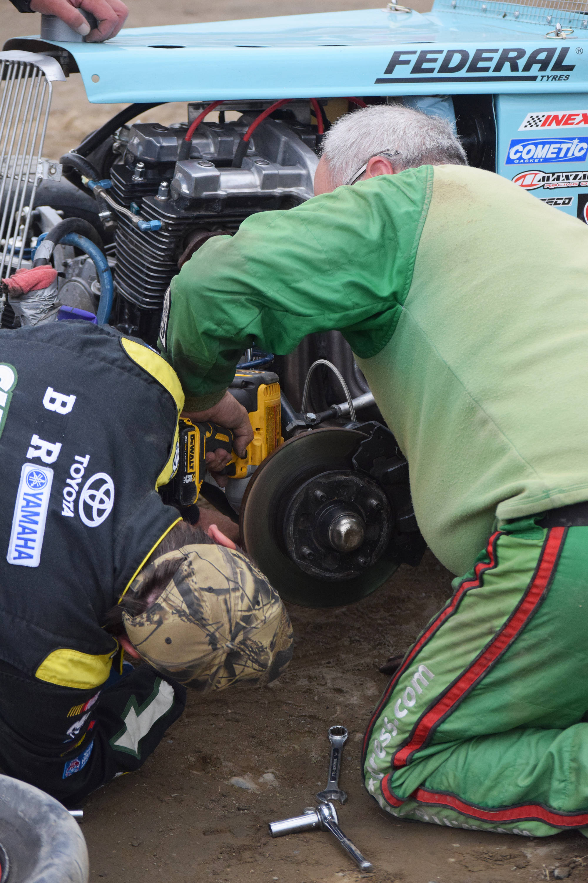 Ty Torkelson (right) makes repairs to his No. 44 Legends car with a teammate Saturday night at Twin City Raceway in Kenai. (Photo by Joey Klecka/Peninsula Clarion)