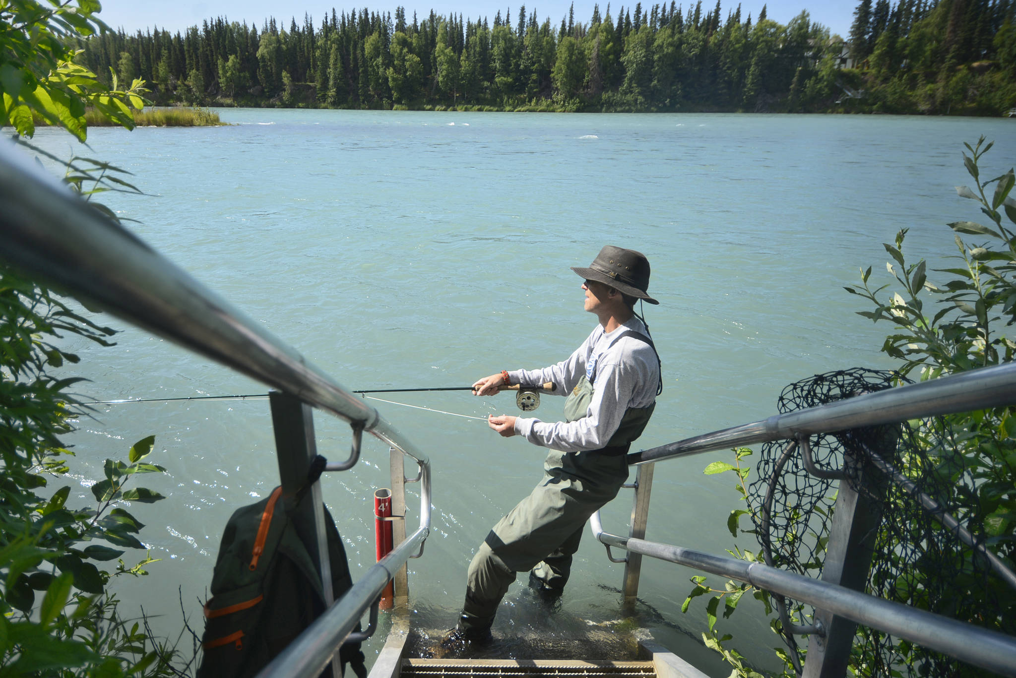 Angler Mark Higgins fishes the Kenai River from the stairs at Centennial Park on Monday, July 16, 2018 in Soldotna, Alaska. It’s the peak of the fishing season, but runs have been far below those of past years — as of Sunday, <a href="https://www.adfg.alaska.gov/sf/FishCounts/index.cfm?ADFG=main.displayResults&COUNTLOCATIONID=40&SpeciesID=420" target="_blank">the Alaska Department of Fish and Game’s sonar had counted a cummulative 105,819 sockeye</a> in the Kenai River this year, versus138,568 sockeye by that date in 2017. Like many anglers on the river, Higgins had an unsucessful Monday afternoon. “Chances are low, but you might as well be fishing rather than sitting in the camper,” he said. (Ben Boettger/Peninsula Clarion)