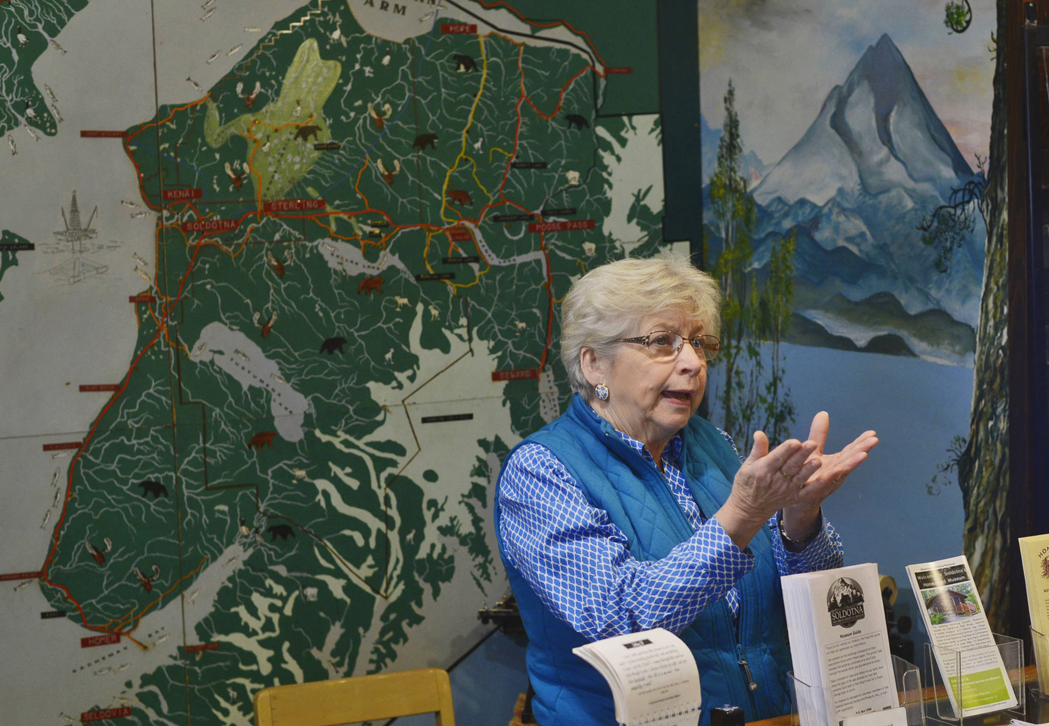 Docent Carroll Knutson describes Alaska’s 1964 earthquake to visitors of the Soldotna Historical Society Museum on Tuesday, July 17, 2018 in Soldotna, Alaska. The Historical Society will be kicking off next weekend’s Soldotna Progress Days celebration on July 27 with a free community barbecue featuring several of Soldotna’s early settlers and their descendents. Knutson, whose family began homesteading about eight miles south of Soldotna in 1958, will be among those telling stories and leading tours thorugh the museum’s collection of homesteader cabins and exhibits of artifiacts. The event, from 4 p.m to 7 p.m, will also include music from Hobo Jim, a dutch oven demonstration, and children’s scavenger hunts. (Ben Boettger/Peninsula Clarion)