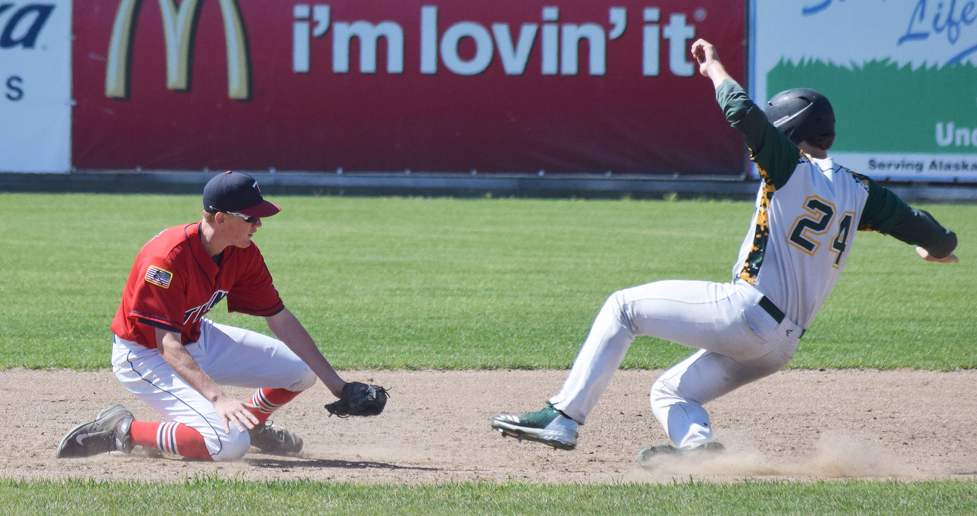 Twins second baseman Austin Asp (left) tags out Service baserunner Carsen Sandau Tuesday afternoon at Coral Seymour Memorial Ballpark in Kenai. (Photo by Joey Klecka/Peninsula Clarion)