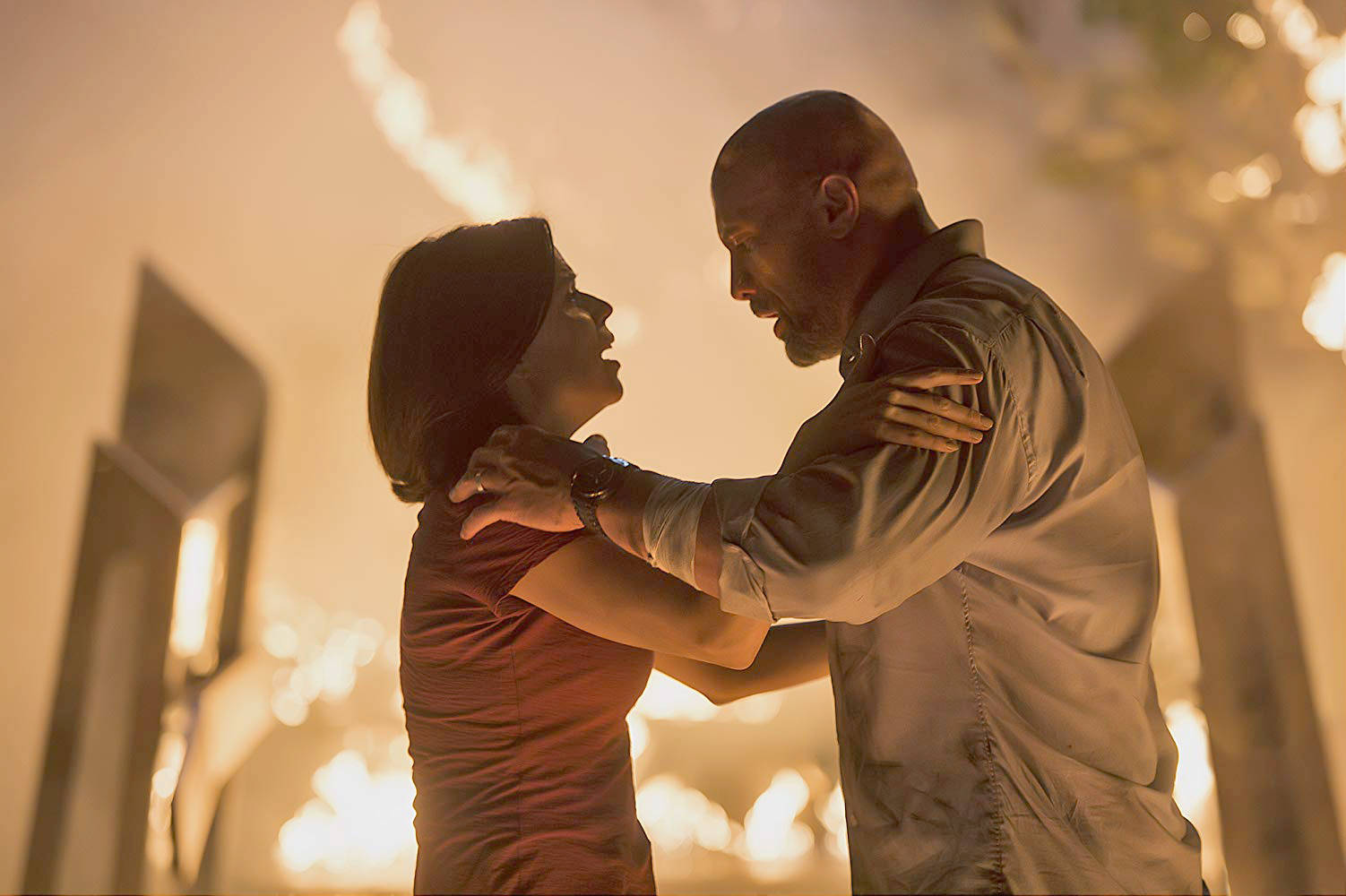 This photo released by Legendary Entertianment, Flynn Picture Company and Seven Bucks Productions shows Dwayne Johnson (right) and Neve Campbell in “Skyscraper.” (Courtesy Legendary Entertianment, Flynn Picture Company and Seven Bucks Productions)