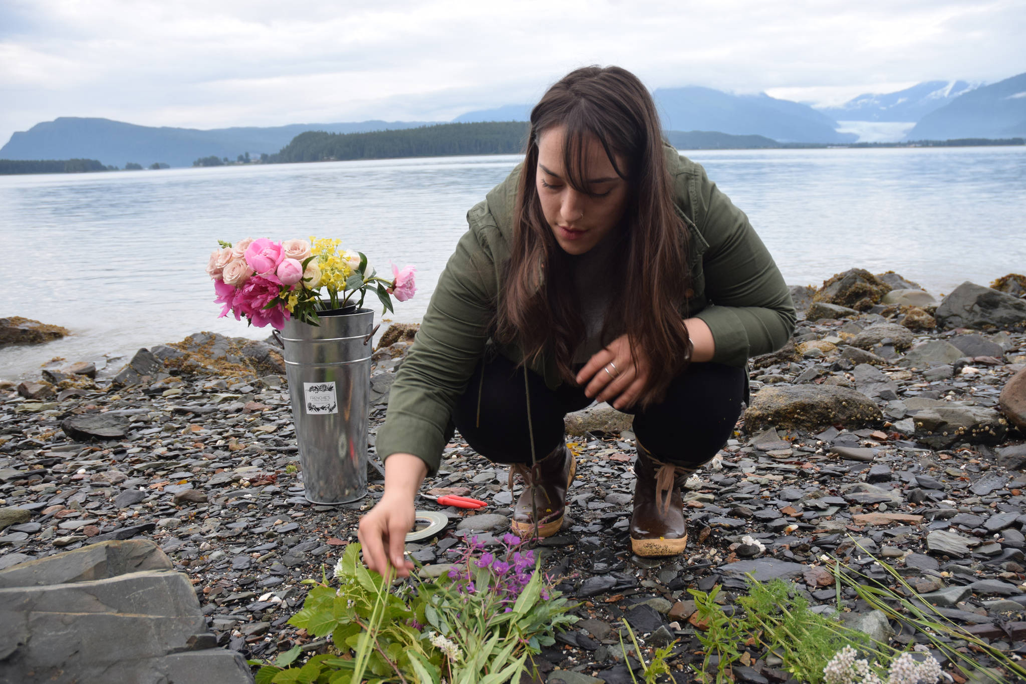 Melissa Garcia Johnson separates foraged wildflowers at a beach on North Douglas Highway. (Photo by Kevin Gullufsen/Juneau Empire)