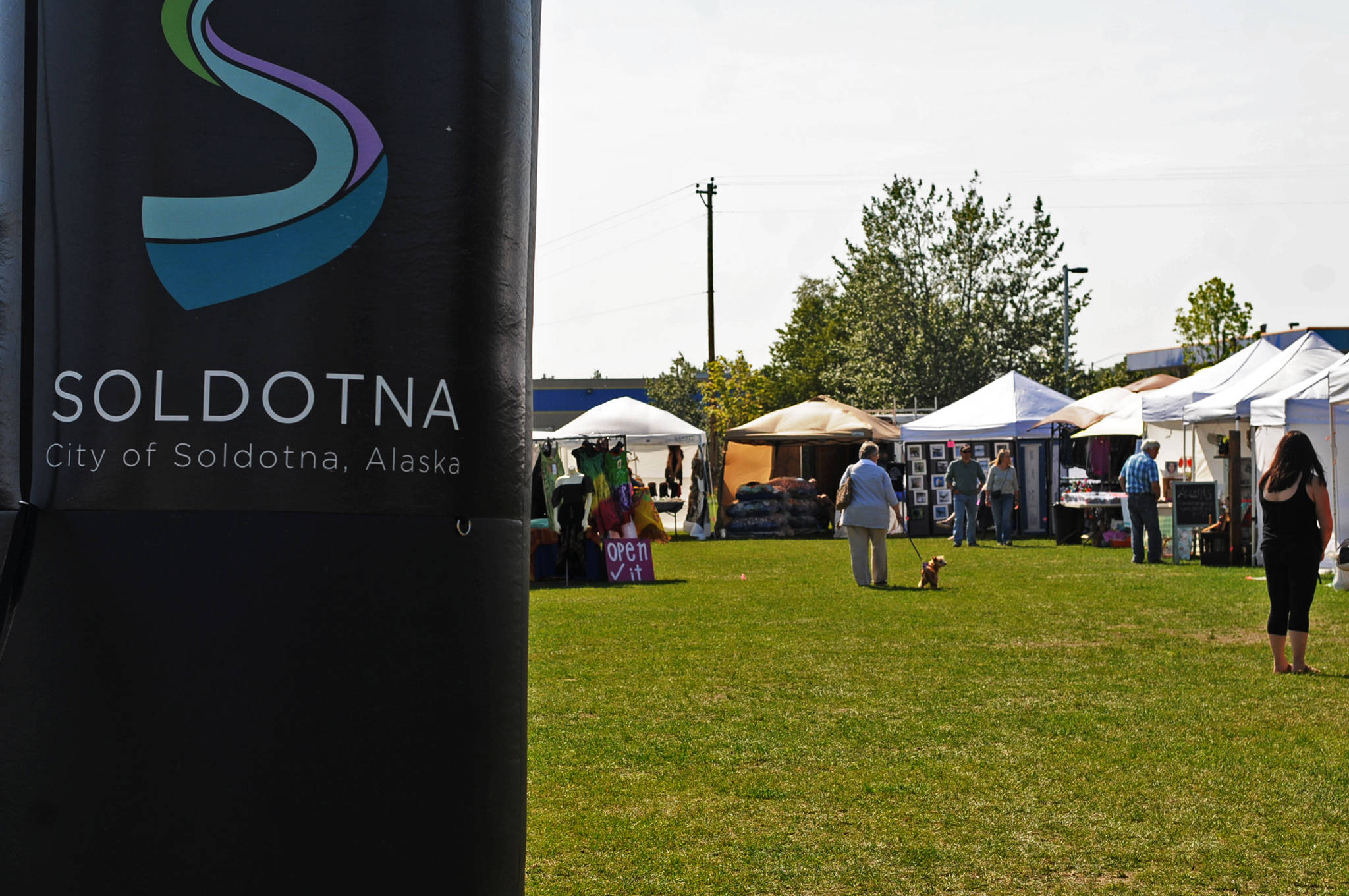In this Wednesday, July 12, 2017 photo, people walk among the stalls at the Soldotna Wednesday Market in Soldotna, Alaska. The Soldotna Chamber of Commerce organizes the market each week for local vendors and features local musicians. (Photo by Elizabeth Earl/Peninsula Clarion, file)