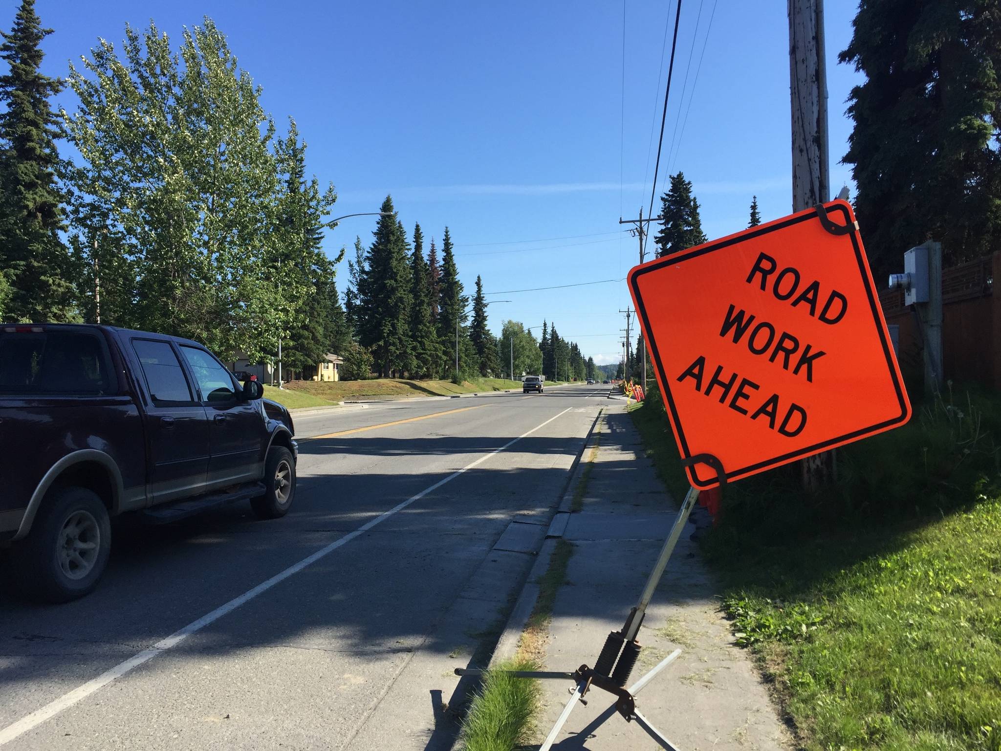 Cars drive past construction signs on Kobuk Street on Thursday, July 19, 2018 in Soldotna, Alaska. (Photo by Elizabeth Earl/Peninsula Clarion)