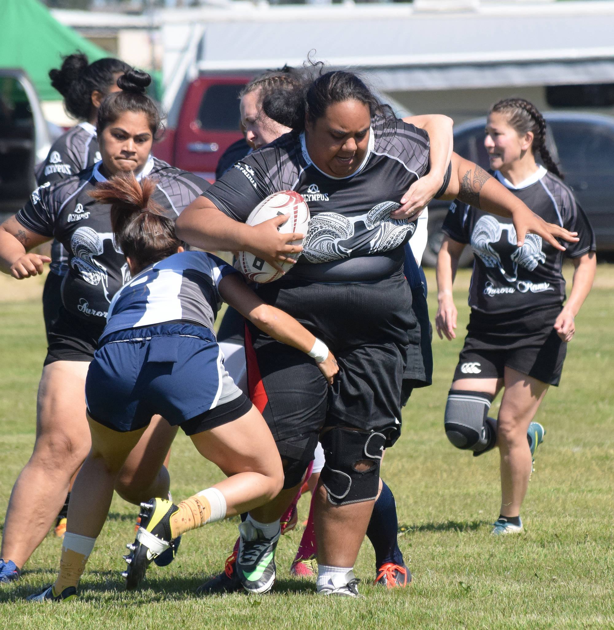 Aurora Rams player Tupe A’asa (with ball) tries to shed tackles from Anchortown players Saturday at the Between the Tides Dipfest Rugby 10’s tournament at Spur View field in Kenai. (Photo by Joey Klecka/Peninsula Clarion)