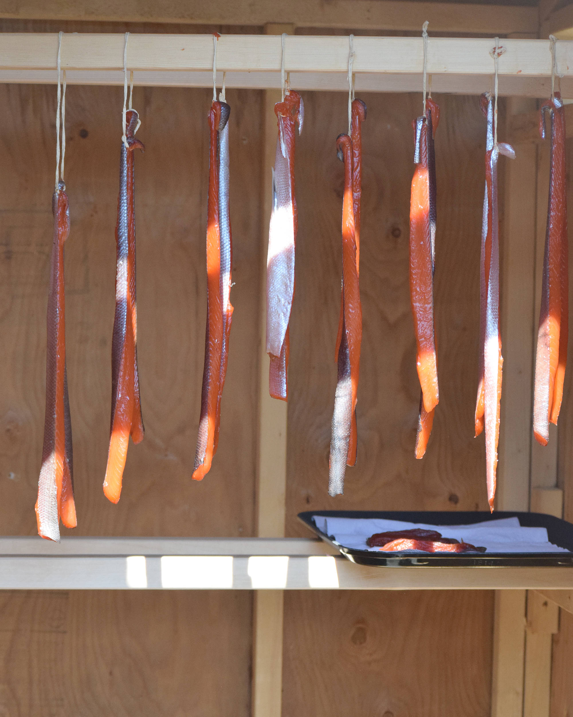 Smoked salmon strips hang in a smoke shed during a demonstration July 20, 2018, at the Kenai National Wildlife Refuge. (Photo by Joey Klecka/Peninsula Clarion)