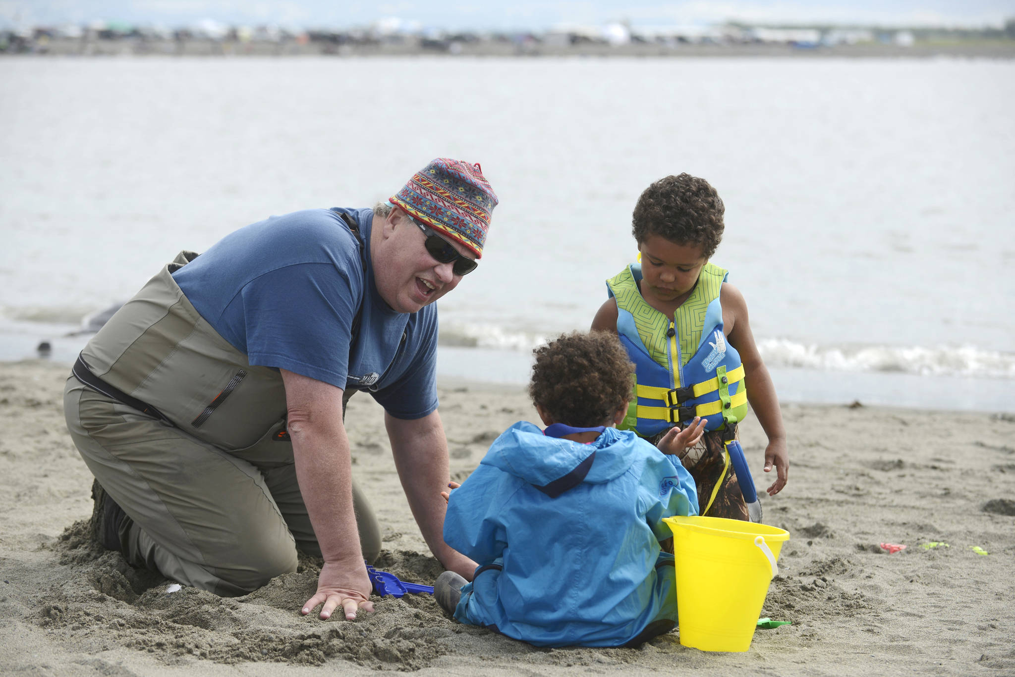 Dipnetter Brad Gamblin (left) digs in the sand of Kenai’s north beach with his grandchildren Stella (in blue) and Marly Wilson on Thursday, July 26, 2018 in Kenai, Alaska. The three, plus grandmother Cher Gamblin, brought the grandchildren on their first dipnetting trip this year. The morning, Brad Gamblin said, “was very productive.” Getting up early, he said the family had caught a dozen salmon by 9 a.m. (Ben Boettger/Peninsula Clarion)