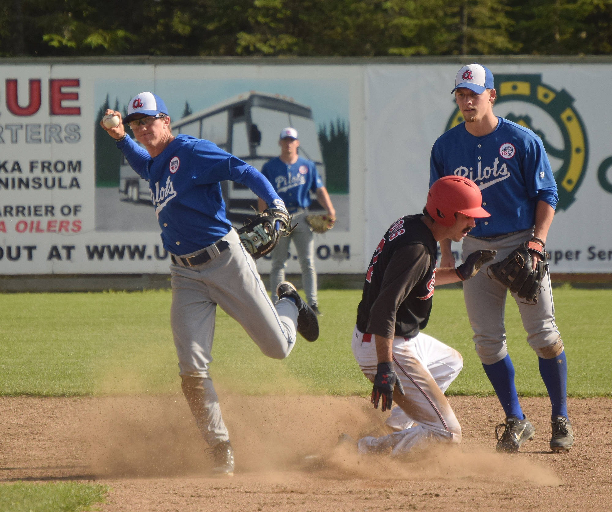 Peninsula Oilers baserunner Ryan Novis attempts to take second while Anchorage Glacier Pilots shortstop Marc Mumper (left) throws to first Friday at Coral Seymour Memorial Park in Kenai. (Photo by Joey Klecka/Peninsula Clarion)