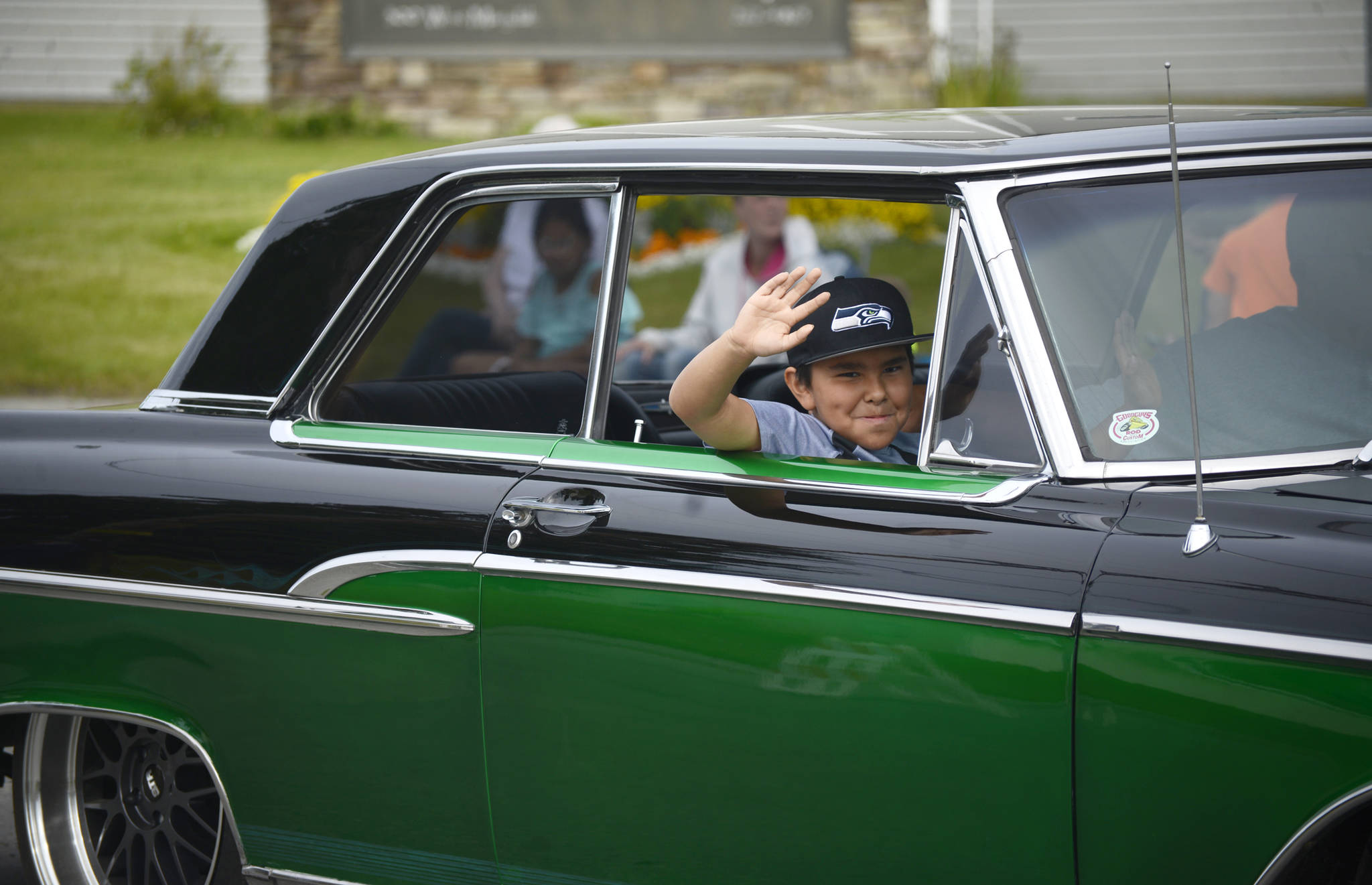 A participant in classic car club Kaknu Kruzers’ display in the Progress Days parade waves to spectators on Saturday, July 28, 2018 in Soldotna, Alaska. The parade kicks off the weekend-long event celebrating Soldotna’s history, with a market on Saturday and Sunday in Soldotna Creek Park and a concert Saturday night followed by a free community barbecue Sunday. (Photo by Elizabeth Earl/Peninsula Clarion)