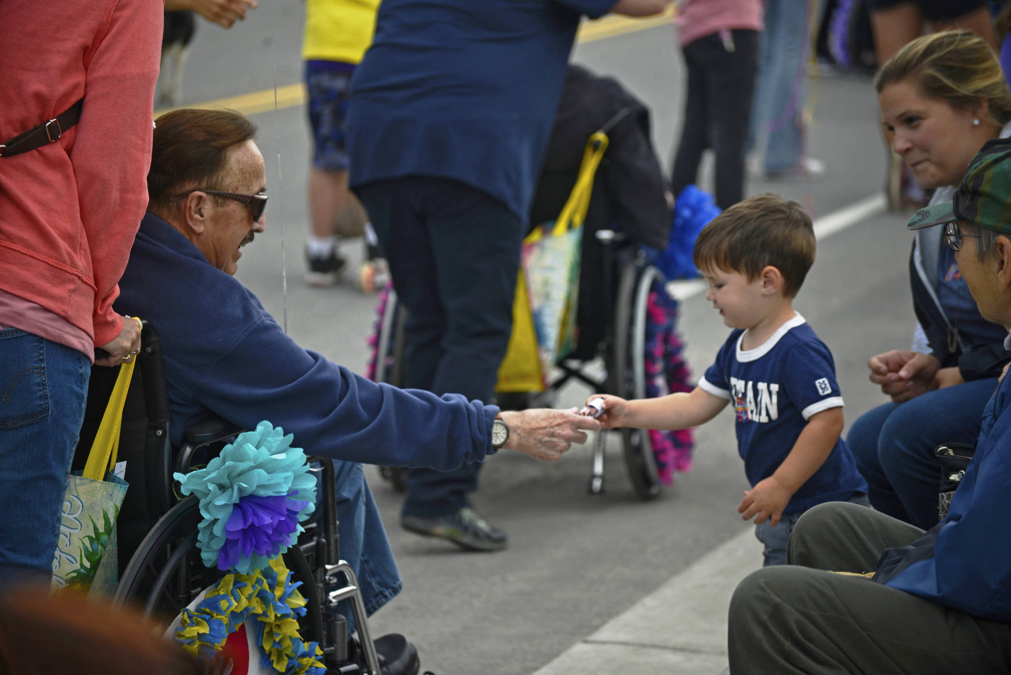 A participant in Heritage Place’s entry in the Progress Days parade hands a piece of candy to a young spectator as the group makes its way down Marydale Avenue on Saturday, July 28, 2018 in Soldotna, Alaska. The parade kicks off the weekend-long event celebrating Soldotna’s history, with a market on Saturday and Sunday in Soldotna Creek Park and a concert Saturday night followed by a free community barbecue Sunday. (Photo by Elizabeth Earl/Peninsula Clarion)