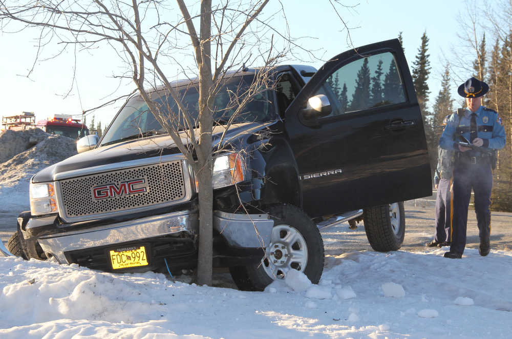 Photo by Dan Balmer Peninsula Clarion Alaska State Trooper Timothy Tefft fills out his report following a two-vehicle collison on Kalifornsky Beach Rd Wednesday morning. The driver of the truck collided with a sedan before hitting the tree in front of the Duck Inn. The driver of the sedan was ejected from his vehicle and was taken to CPH for facial lacerations before being released.