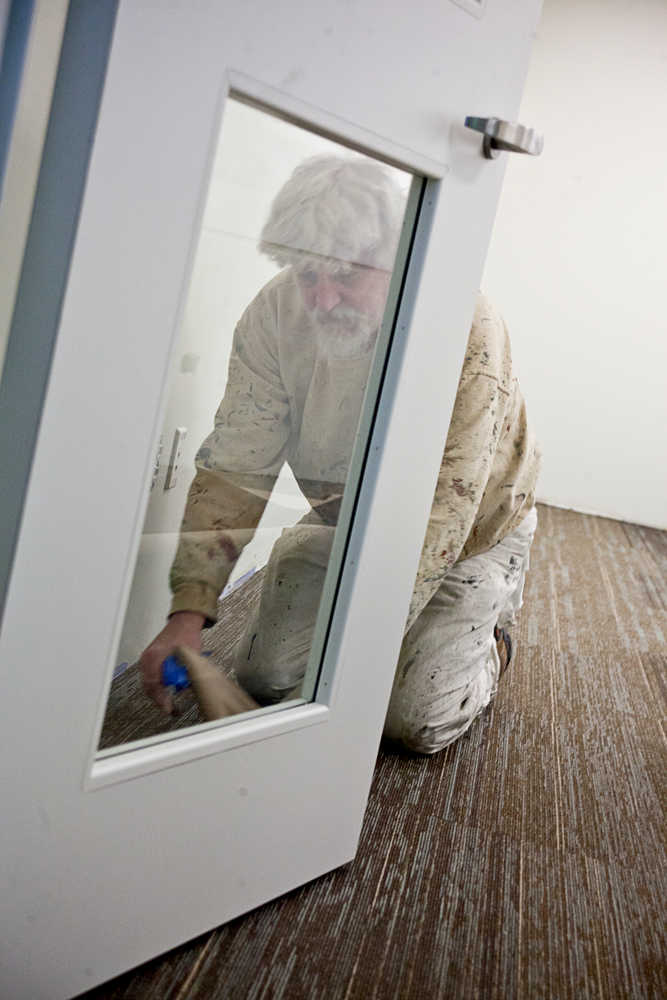 Photo by Rashah McChesney/Peninsula Clarion  Mike Gangloff works to clear paper off of the floor of a room he painted at the new Dena'ina Wellness Center Wednesday Jan. 29, 2014 in Kenai, Alaska.