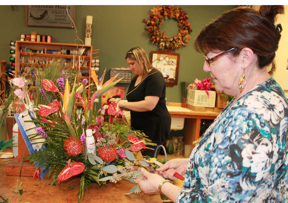 Photo by Dan Balmer Peninsula Clarion Debbie Morris (front) and Tonya Gilmore prepare ordered flower arrangements at Tammy's Flowers and Gifts in Soldotna Thursday. Morris runs the Candy Botique in the shop with the help of her husband Mike. The two have been married for 42 years and met in high school when she used to work at a flower shop in Oregon, Morris said.