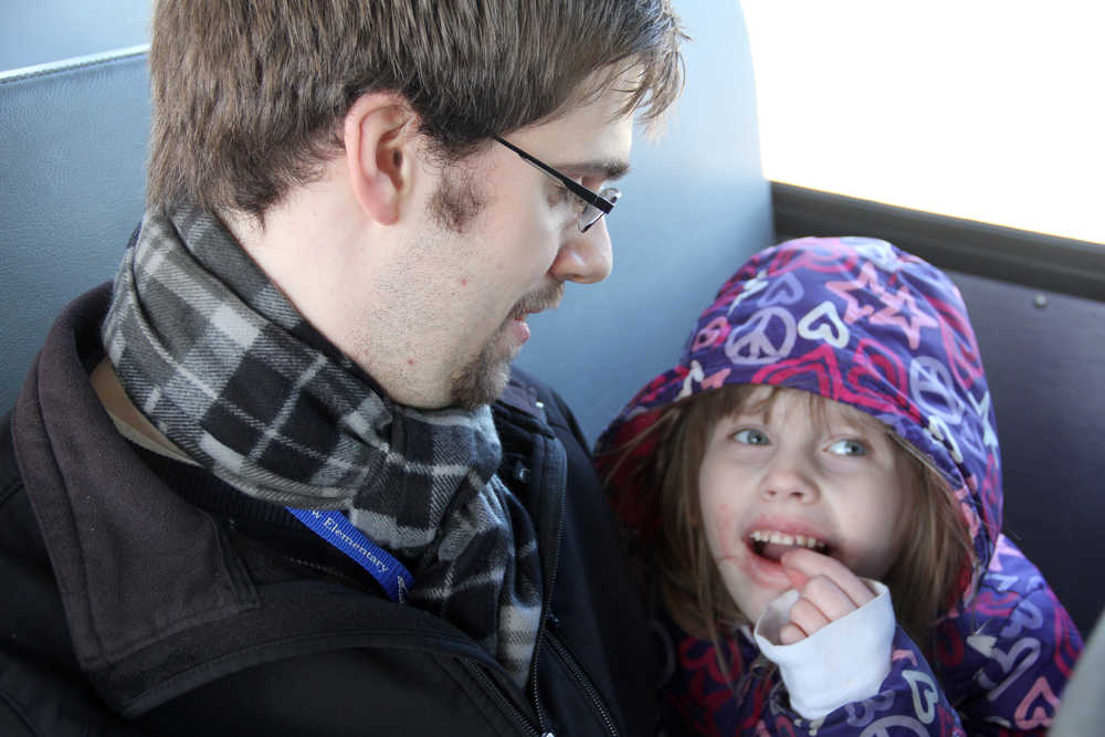 Mountain View Elementary School music teacher Jonathan Dillon sits next to student Harley Farabee before the bus takes off for its afternoon route. Teachers from the Kenai school joined students for their bus rides to promote bus safety and good bus behavior on Wednesday. Photo by Kaylee Osowski/Peninsula Clarion