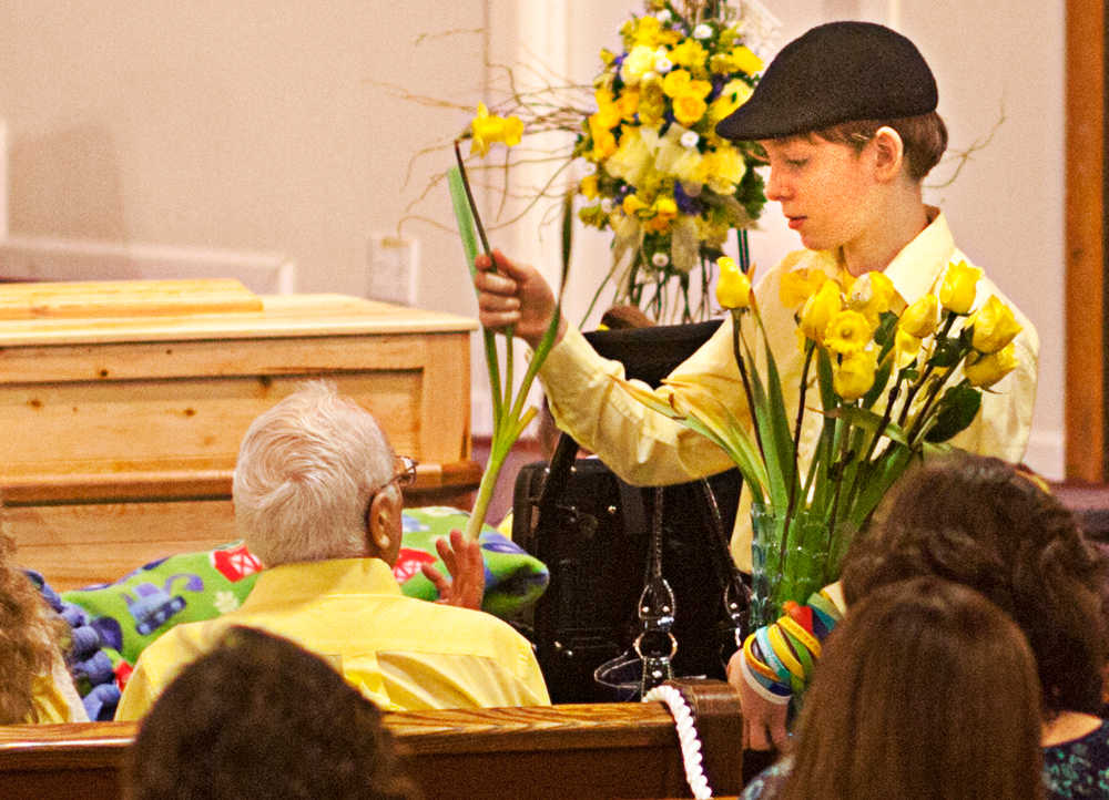 Photo by Rashah McChesney/Peninsula Clarion  Several people passed yellow flowers to audience members Tuesday Feb. 18, 2014 during a memorial for 6-year-old Floyd Murphy at the Soldotna Nazarene Church in Soldotna, Alaska.