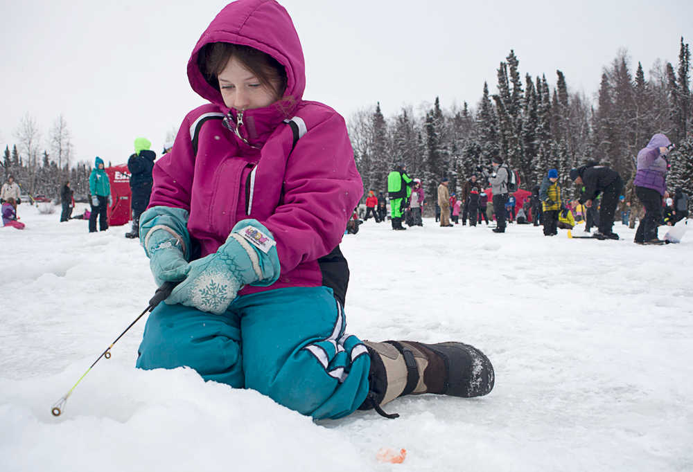 Photo by Rashah McChesney/Peninsula Clarion  Clare Henry, a student from Cook Inlet Academy, waits for a fish to bite Wednesday Feb. 19, 2014 during the Alaska Department of Fish and Game's ice fishing day, part of its Salmon in the Classroom curriculum, on Sport Lake in Soldotna, Alaska.