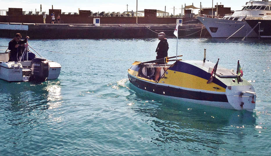 In this image released by G.C. Media, Victor Mooney, right, stands inside his custom built row boat "The Spirit of Malabo," as he prepares for the Goree Challenge, his fourth attempt at crossing the Atlantic to raise funds for HIV/AIDS, on Wednesday Feb. 19, 2014 in Maspolamas, Gran Canaria.  (AP Photo/G.C. Media,Handout)