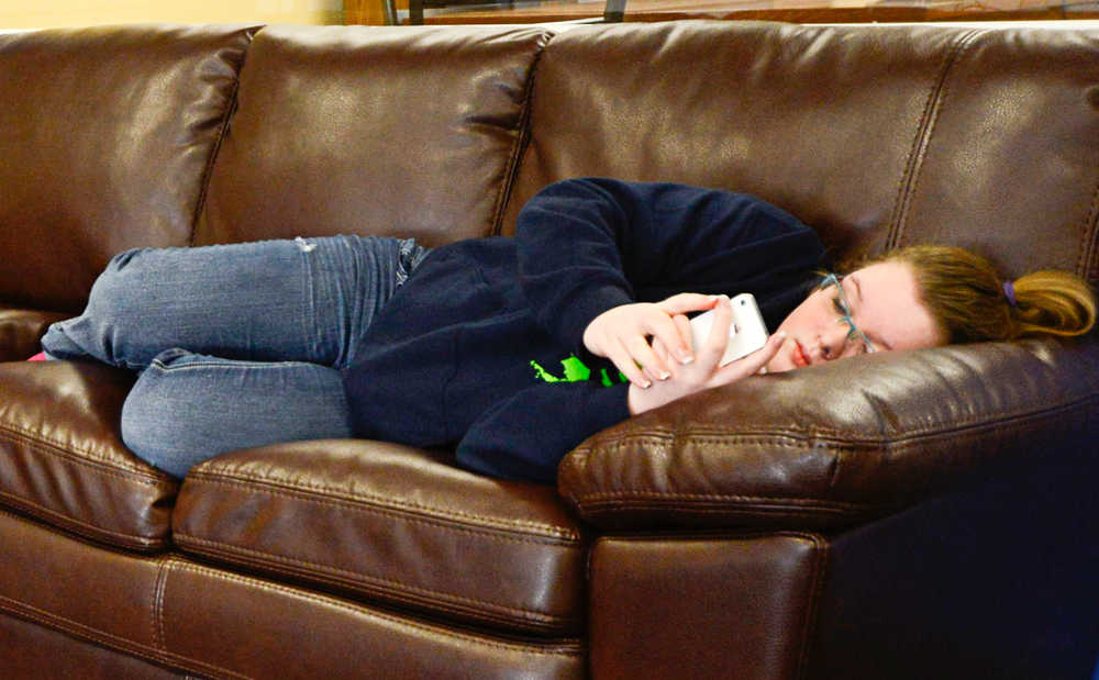 Photo by Rashah McChesney/Peninsula Clarion  Morgan Patterson, 15, reads as she reclines on a couch Thursday Feb. 20, 2014 at the teen center in Soldotna, Alaska.