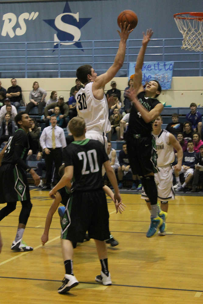 Soldotna's Daniel McElroy attempts a floater over Colony's Damien Fulp, Saturday at Soldotna High School. The Stars lost 65-43.