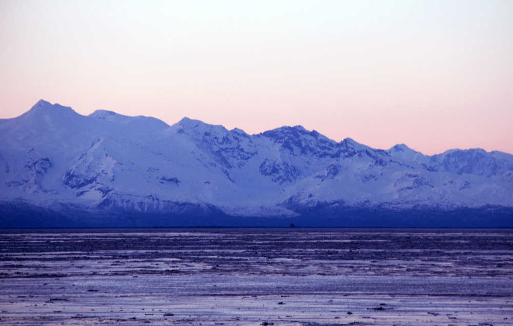 The setting sun paints the sky pink behind the mountains viewable from Nikiski Beach Road in Nikiski on Monday evening. Photo by Kaylee Osowsk/Peninsula Clarion