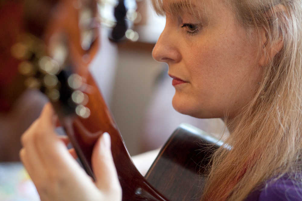 Photo by Rashah McChesney/Peninsula Clarion  Classical guitarist Valerie Hartzell plays a piece at Maria Allison's house Wednesday March 5, 2014 in Kenai, Alaska. Hartzell will be giving a solo concert Friday at the Christ Lutheran Church, 128 N Soldotna Ave., at 7:30 p.m. The program will include a mixture of classical and more contemporary pieces and tickets are $20 for general admission and $10 for students.