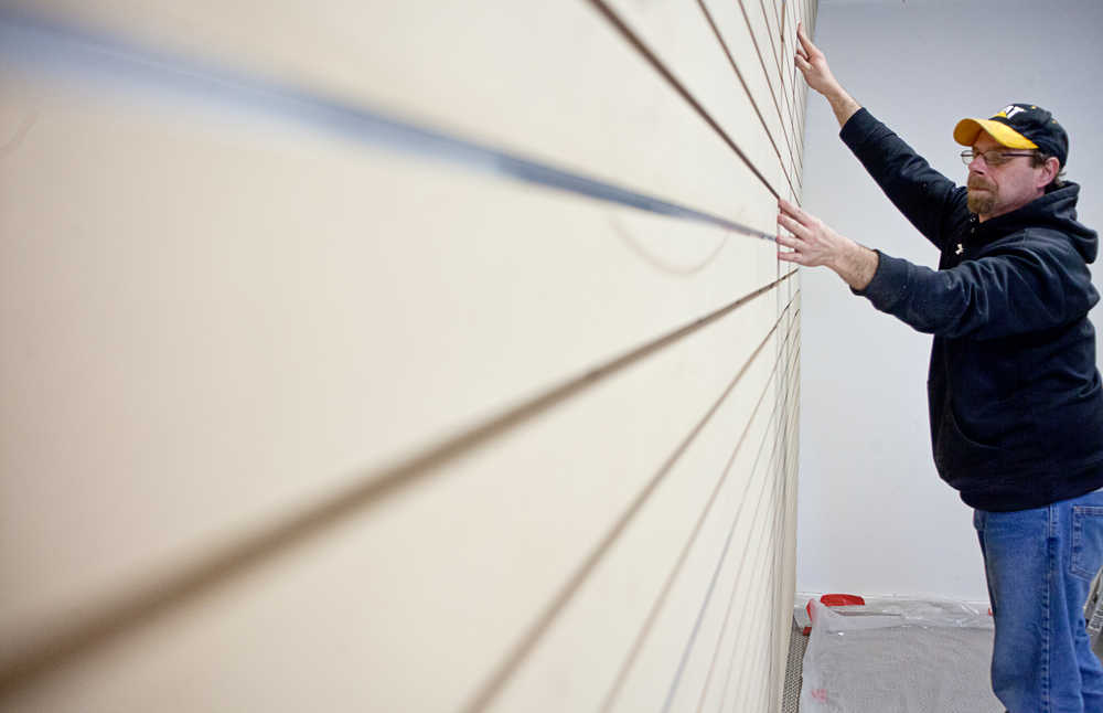 Photo by Rashah McChesney/Peninsula Clarion  Paul Minelga, owner of elfworks handyman services, measures portions of a wall for slat wall installation Wednesday March 5, 2014 at the Kenai Fine Arts Center in Kenai, Alaska.