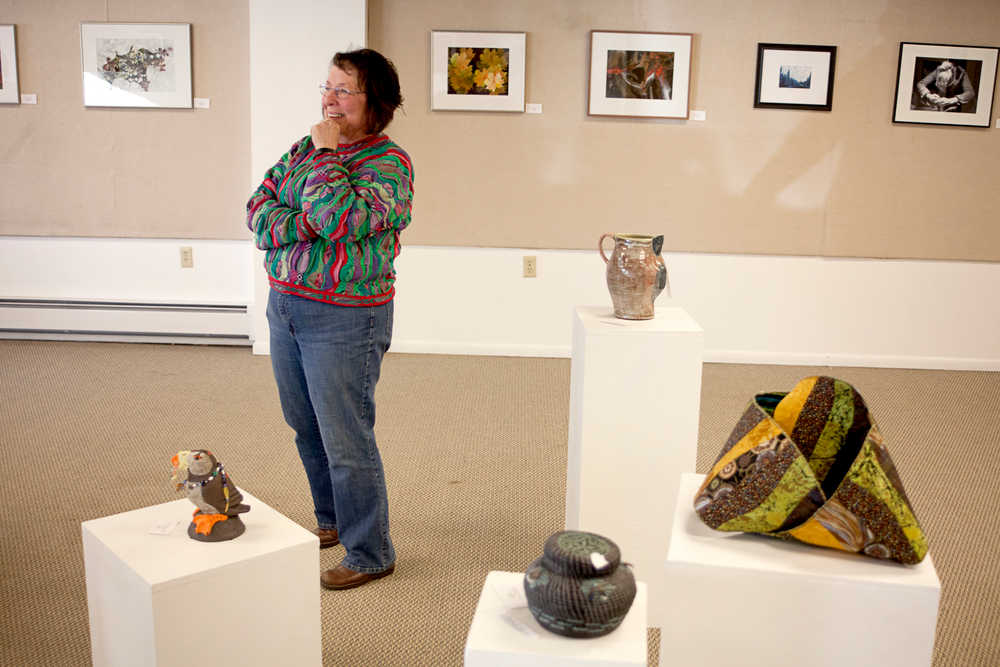 Photo by Rashah McChesney/Peninsula Clarion  Karen Fogarty, volunteer coordinator at the Kenai Fine Arts Center, stands among several pieces on display for an upcoming juried show Wednesday March 5, 2014 in Kenai, Alaska.