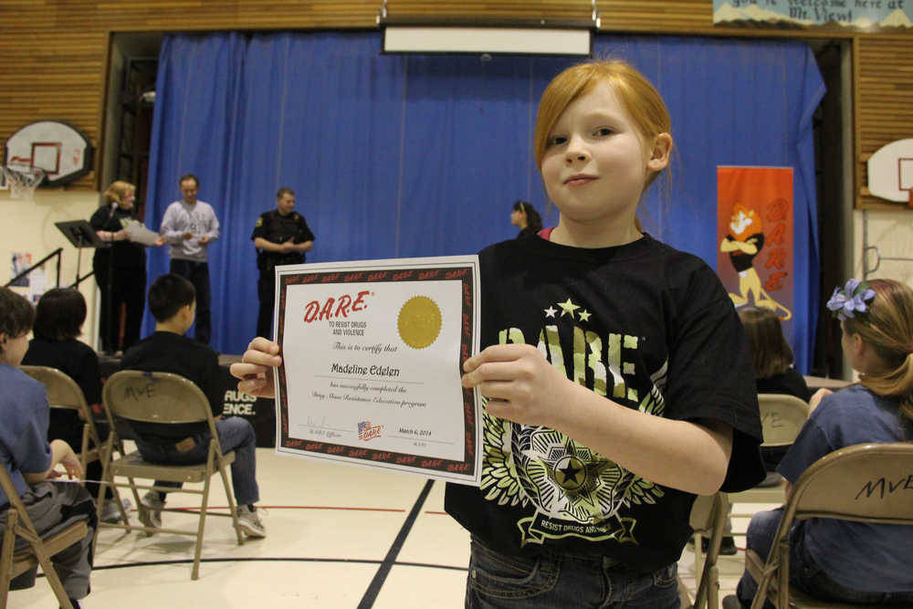 Photo by Dan Balmer/Peninsula Clarion Madeline Edelen, a fifth grader at Mountain View Elementary, displays her certificate after graduating the DARE program Thursday night. Edelen was one of three students chosen to read her essay at the graduation.