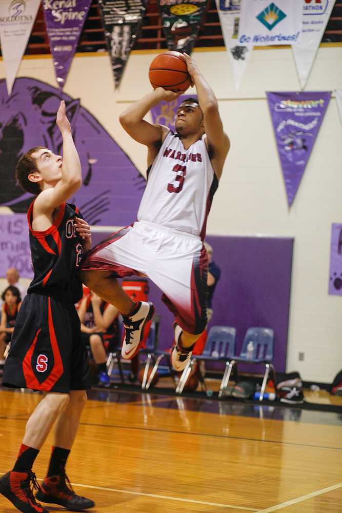 Photo by Rashah McChesney/Peninsula Clarion  Seldovia Sea Otter Calem Collier watches as Nikolaevsk Warrior Jaruby Nelson shoots during their game Friday March 7, 2014 at Skyview High School in Soldotna, Alaska.