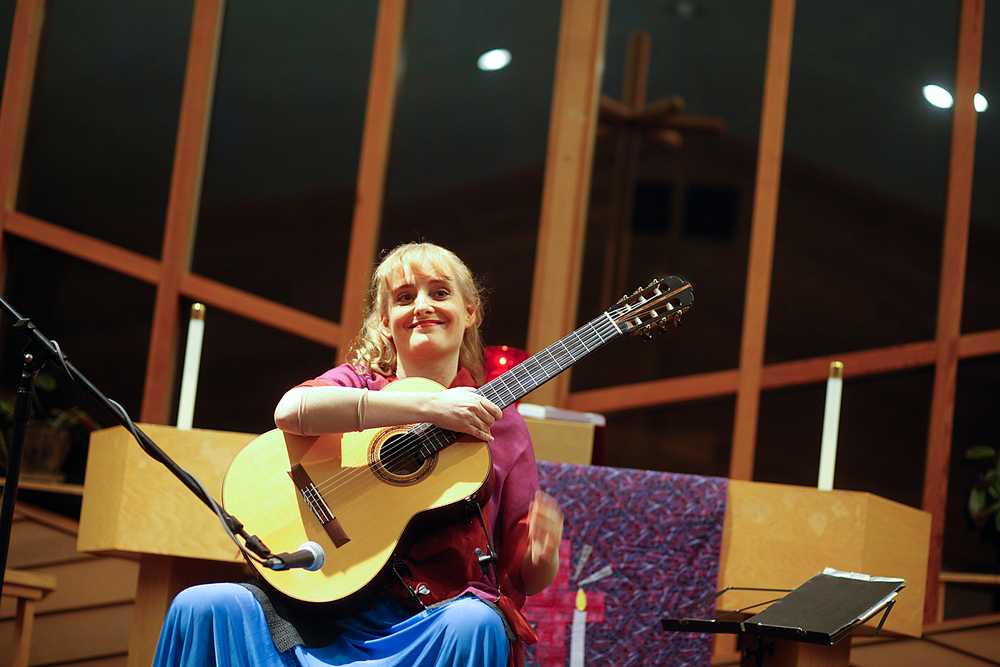 Photo by Rashah McChesney/Peninsula Clarion  Classical guitarist Valeria Hartzell grins at the audience after her opening piece - an adaption of the prelude for Bach's unaccompanied cello suite 1 - Friday March 7, 2014 in Soldotna, Alaska.