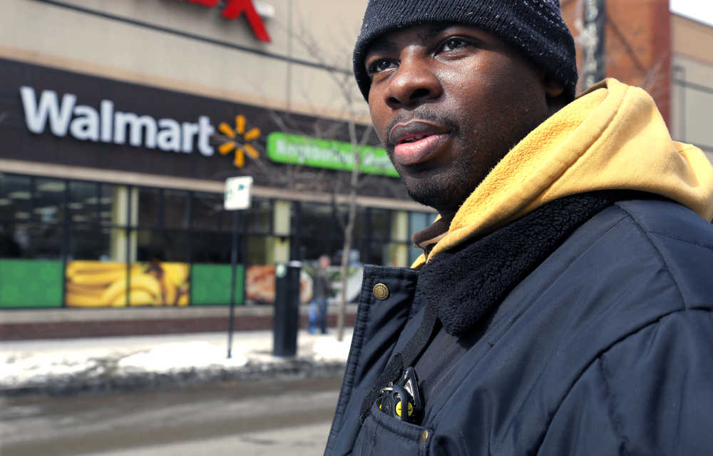 In this Tuesday, March 4, 2014, photo, Wal-Mart employee Richard Wilson, 27,  is photographed outside the store where he works in Chicago. Wilson earns $9.25 an hour at that Wal-Mart and lives on the city's western edge with his grandmother. (AP Photo/M. Spencer Green, File)