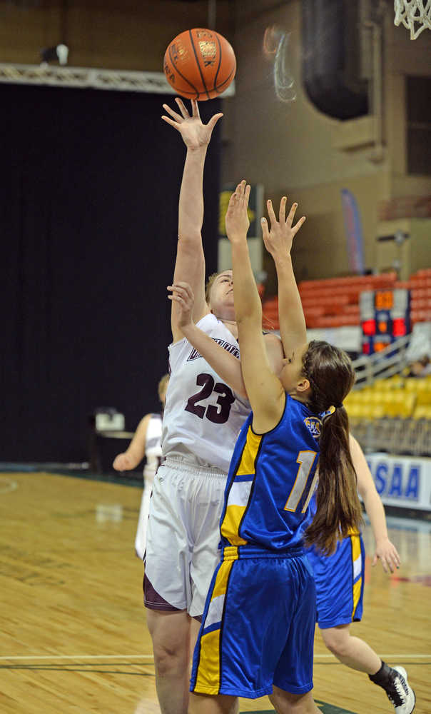 Nikolaevsk's Nianiella Dorvall (32) scores over Cook Inlet Academy's Nicole Moffis (11) during the 1A girls third-place game at the 2014 high school state basketball championships at Anchorage's Sullivan Arena on Wednesday.
