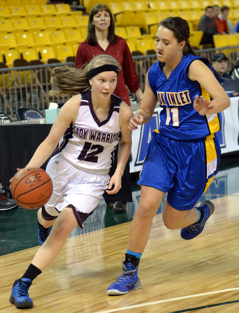 Nikolaevsk's Vera Fefelov (12) drives past Cook Inlet Academy's Nicole Moffis (11) during the 1A girls third-place game at the 2014 high school state basketball championships at Anchorage's Sullivan Arena on Wednesday.