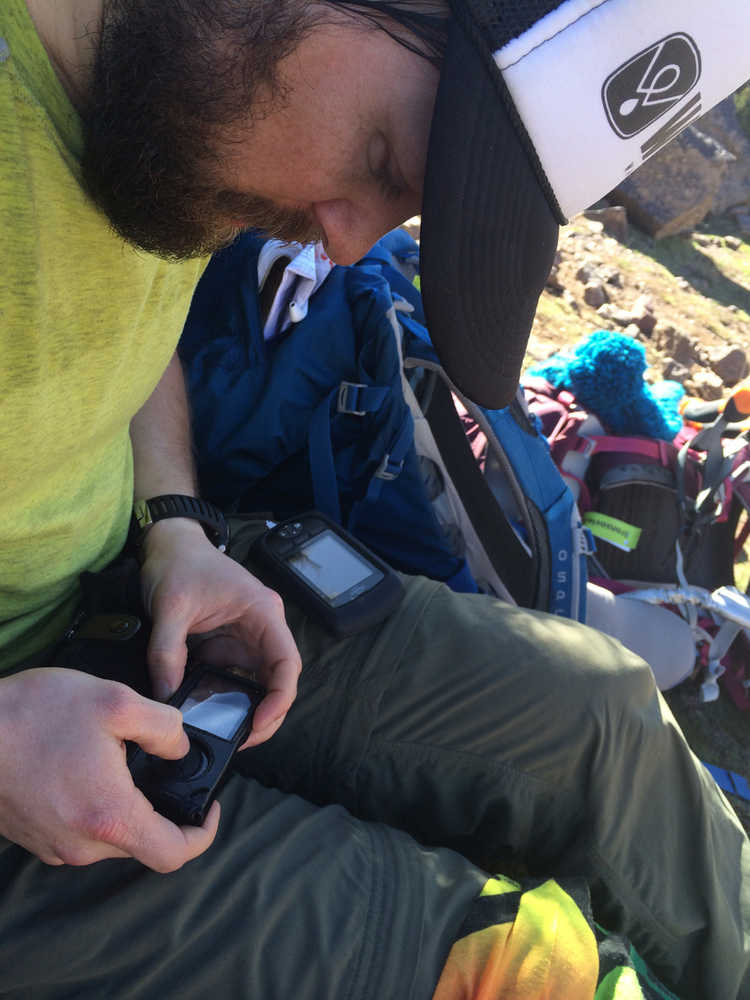 In a February 2014 photo provided by TwoSticksAndABoard.com, Sean Busby checks his insulin pump at base camp in the High Atlas Mountains near Marrakech, Morocco. By riding the highest mountain range in North Africa, Busby became the first person with Type 1 diabetes to snowboard on all seven continents. (AP Photo/TwoSticksAnd ABoard.com)