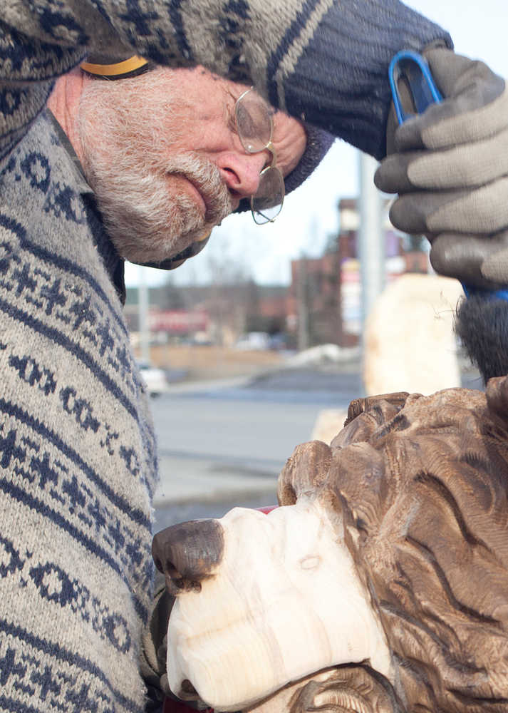 Photo by Rashah McChesney/Peninsula Clarion  Peter Quinn works on a sculpture as an apprentice with Derrick Stanton Log Works Tuesday March 25, 2014 at a temporary shop set up along the Sterling Highway in Soldotna.