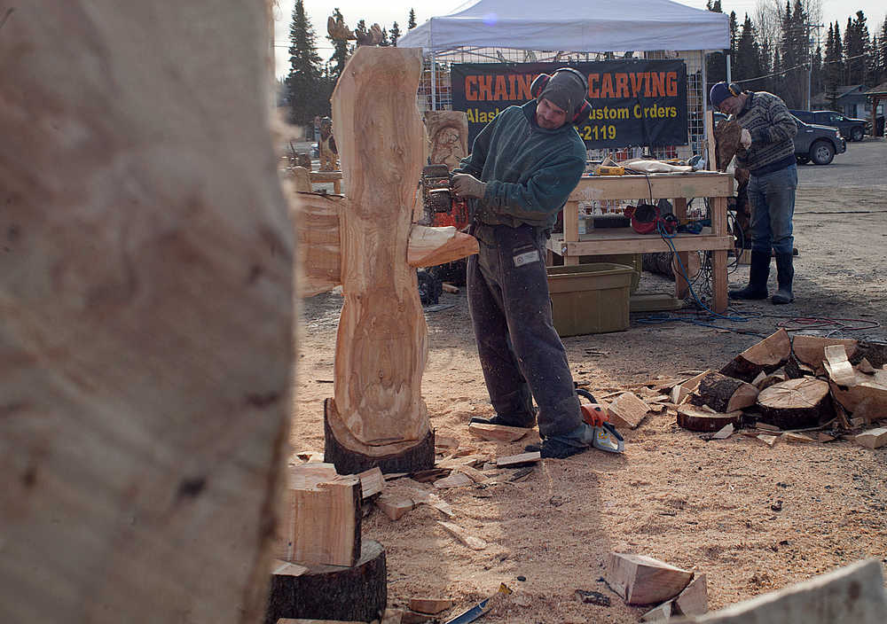Photo by Rashah McChesney/Peninsula Clarion Derrick Stanton and Peter Quinn work on wooden sculptures at a temporary space for Derrick Stanton Log Works Tuesday March 25, 2014 in Soldotna, Alaska. Stanton , whose permanent shop sits at the corner of Kalifornsky Beach road and Beach Access Road in Kenai saidhe would be in Soldotna through Saturday.