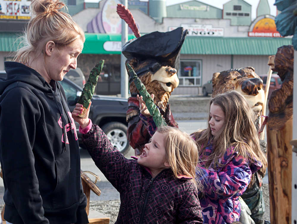 Photo by Rashah McChesney/Peninsula Clarion  Jesley Hanke looks at her daughter MacKinsey Hanke, 5, as Grayce Hanke, 8, plays with a wooden carving from Derrick Stanton Log Works in the background Tuesday March 25, 2014 in Soldotna, Alaska.