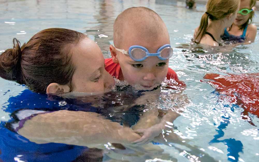 Photo by Rashah McChesney/Peninsula Clarion Kim McMilin coaxes Andrew Thompson, 5, into putting his face into the water and blowing bubbles Tuesday Feb. 5, 2013 at the Skyview High School pool in Soldotna, Alaska. Thompson and about 20 other children were in the water during the February session of their Swim America swimming lessons.