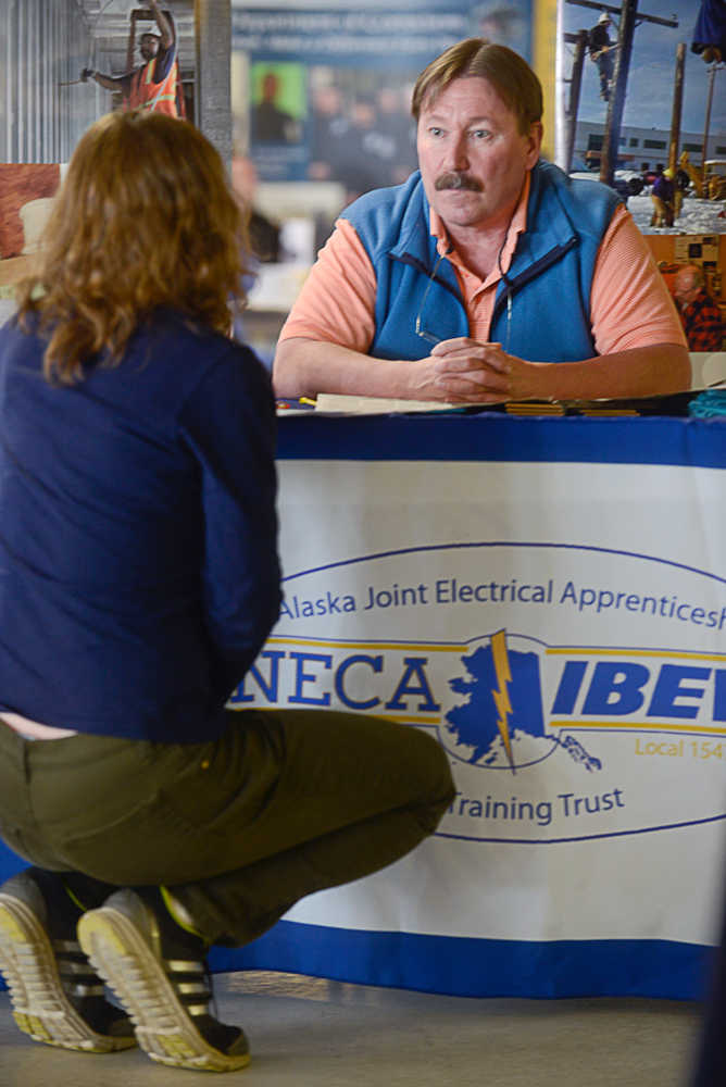 Photo by Rashah McChesney/Peninsula Clarion  Nina Kovac talks to Charlie Breitenstein about the electrician apprentice program, the product of a partnership between the National Electrical Contractor's Association and the International Brotherhood of Electrical Workers, during the Kenai Peninsula Job Fair Wednesday March 26, 2014 in Kenai, Alaska.