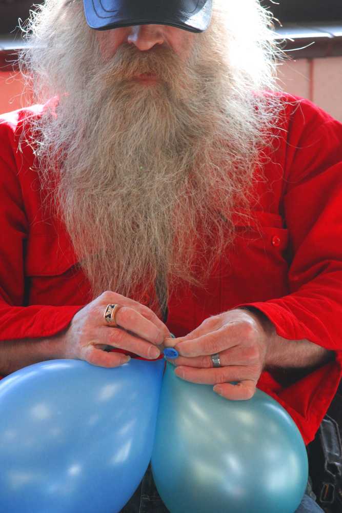 Jerry Terp concentrates on tying balloons together for the Spring Fling, Friday, March 28, at the Soldotna Sports Center.