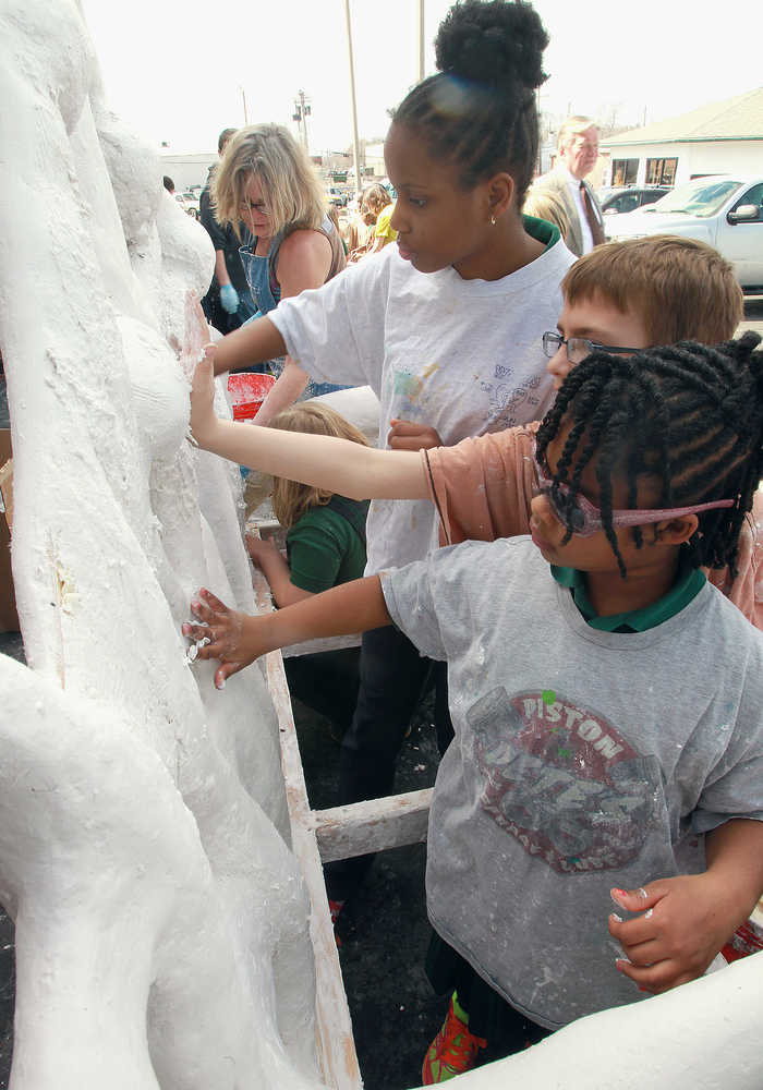 ADVANCE FOR USE SUNDAY, MARCH 30 AND THEREAFTER - In this March 11, 2014 photo, artist Marina Lee, left, of Milwaukee, works on a sculpture with Governor French Academy third and fourth-grade students for the Art on the Square's fourth annual High School Sculpture in the City Program in Belleville, Ill. The students are from left: Macee Rivers, 10; Vincent Garavalia, 9, and Skylar Hunter, 8. (AP Photo/Belleville News-Democrat, Tim Vizer)