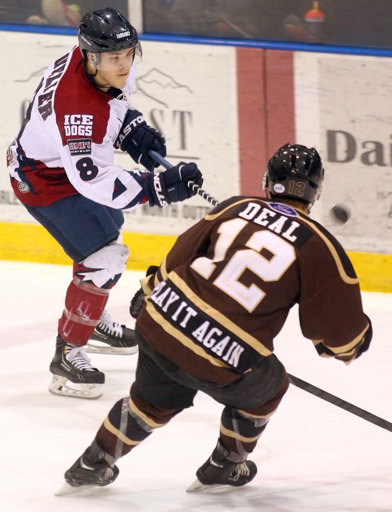 Fairbanks Ice Dogs forward Johnny Mueller sends the puck past Kenai River Brown Bears forward Conor Deal during the second period of their playoff game Friday night, April 4, 2014, at the Big Dipper Ice Arena.  Sam Harrel/News-Miner